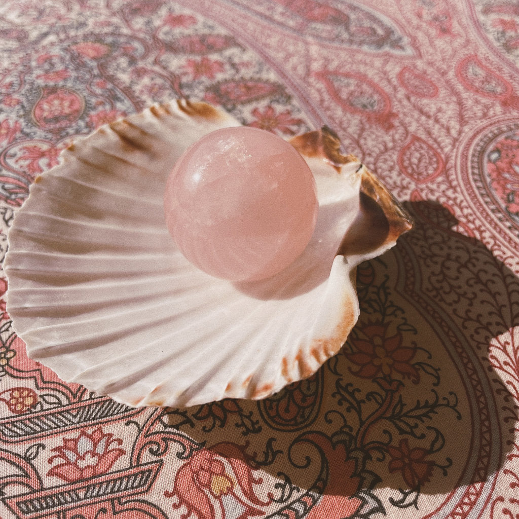 1 rose quartz ball of Akasha blends in an open shell on a nice pattern background