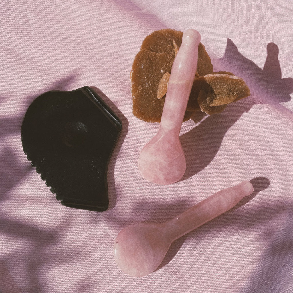 Two Akasha blends Rose Quartz Spoons with one Guasha board on pink background